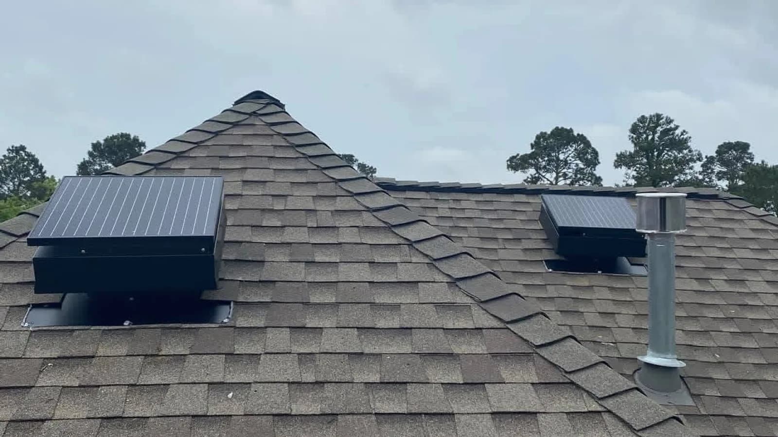 Two solar attic fans installed on a hip-roof ridge