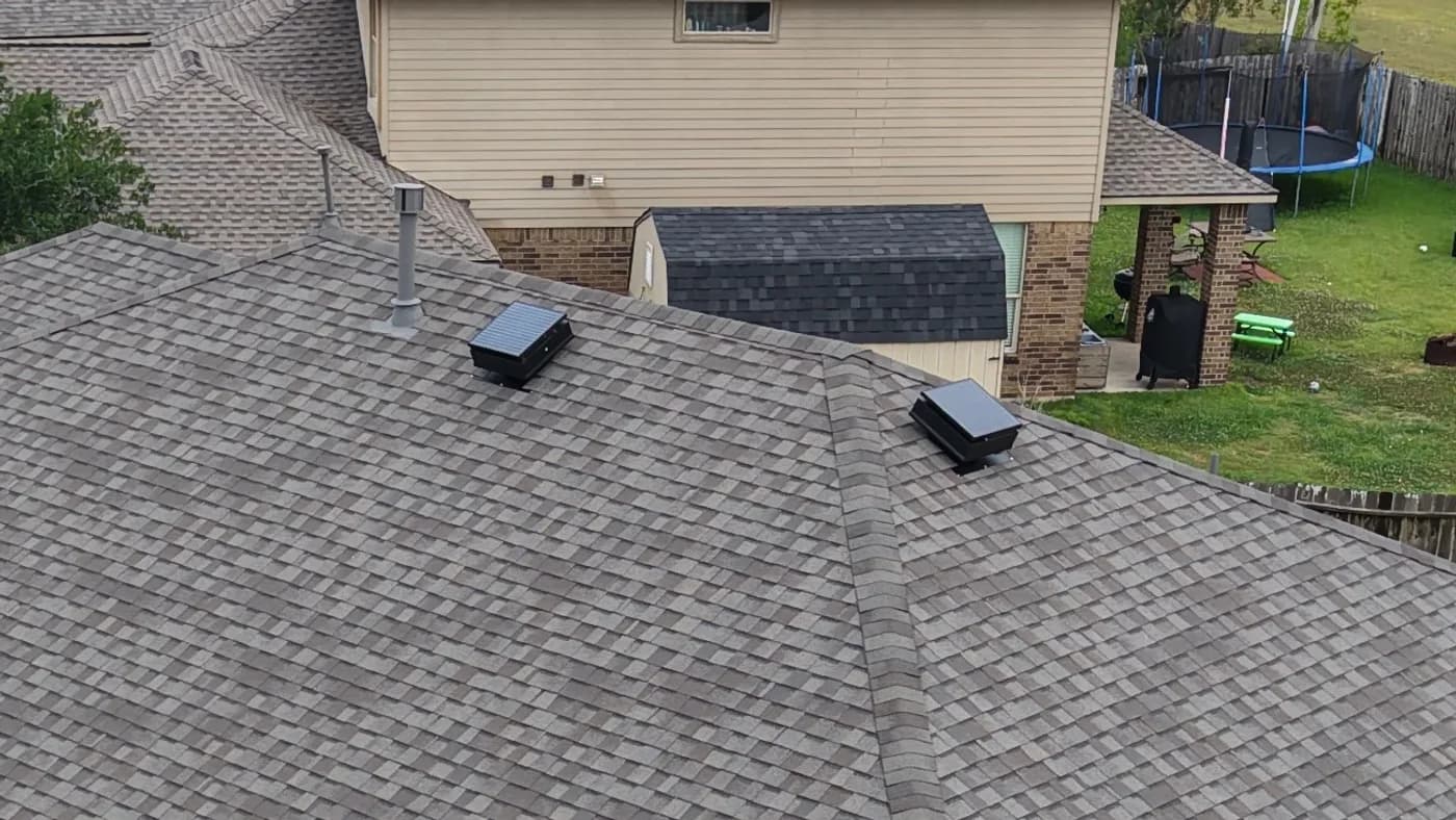 Aerial view of two solar attic fans installed flat on a residential roof
