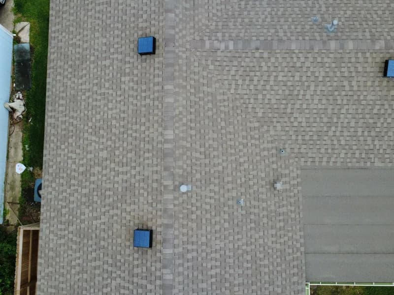 Drone view of a home with a solar attic fan installed